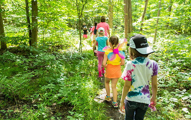 Group of seven girls hiking in the woods.